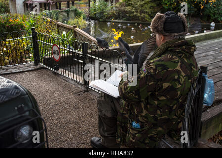 The retired social worker Richard Thomason can be found drawing birds in London Parks 3-4 times a week. Here he sits in front of the Swiss Cottage at  Stock Photo