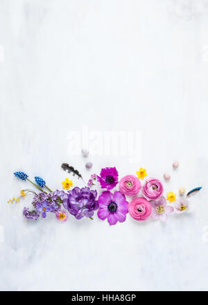 deconstructed spring flower arrangement shot from above in natural light with feathers and mini eggs Stock Photo