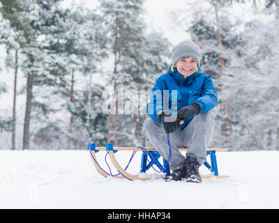 Child play in snow with sled Stock Photo