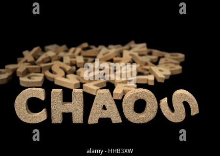 word chaos in jumbled cork letters on black Stock Photo