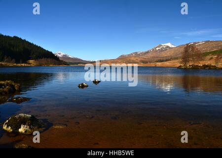 Loch Poulary on a clear blue day with mountain peaks of Knoydart, Scotland in the distance Stock Photo