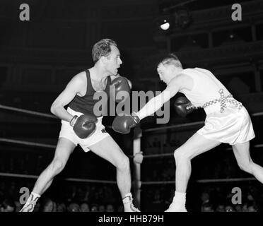 R Russell (right) of Hull Boys' Club forces Manfred Mae (Berlin) to retreat in their featherweight bout in the international amateur boxing match between England and West Germany at the Royal Albert Hall, London. Mae won, the referee stopping the fight in the second round because of  a cut eye sustained by Russell. Stock Photo
