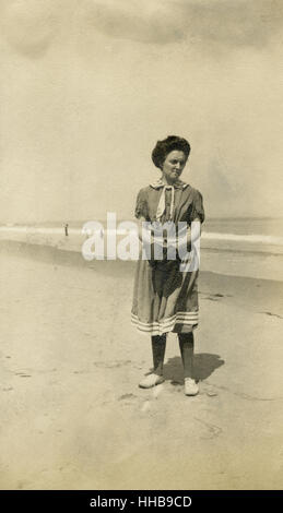Antique 1908 photograph, woman on beach in Victorian style bathing suit. Location: New England, USA. SOURCE: ORIGINAL PHOTOGRAPHIC PRINT. Stock Photo