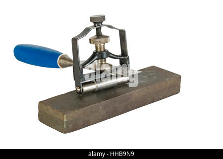 Studio shot of chisel clamped in angle guide jig resting on grinding whetstones on white background Stock Photo
