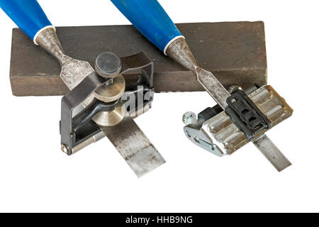 Studio shot of two chisels clamped in angle guide jigs resting on grinding whetstones on white background Stock Photo