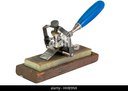 Studio shot of chisel clamped in angle guide jig resting on grinding whetstones on white background Stock Photo