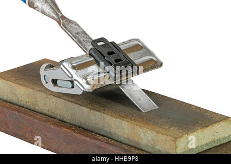 Close up studio shot of chisel clamped in angle guide jig resting on grinding whetstones on white background Stock Photo