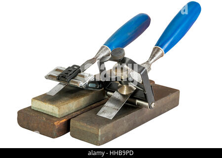 Studio shot of two chisels clamped in angle guide jigs resting on grinding whetstones on white background Stock Photo