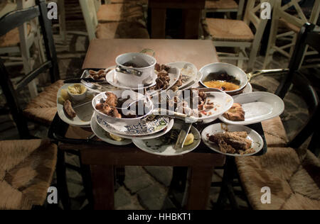 Leftover food on stacked plates in a restaurant, (Greek Taverna, Chania) Stock Photo