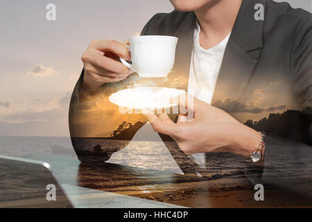 Double exposure of business woman drink a coffee,tea and sunrise on the beach. Stock Photo