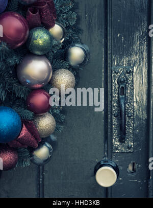 Beautiful close up of old fashioned retro vintage style Christmas wreath hanging on wooden door Stock Photo