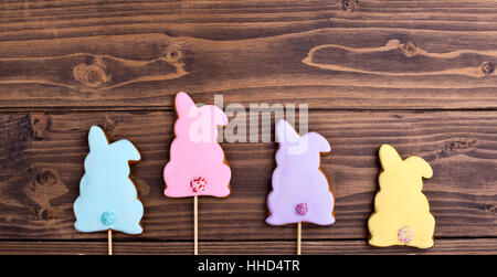 Row of nice gingerbread bunnies on a wooden background Stock Photo
