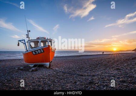 Fishing boat moored on Branscombe Beach at sunset, Seaton, East Devon, UK Stock Photo