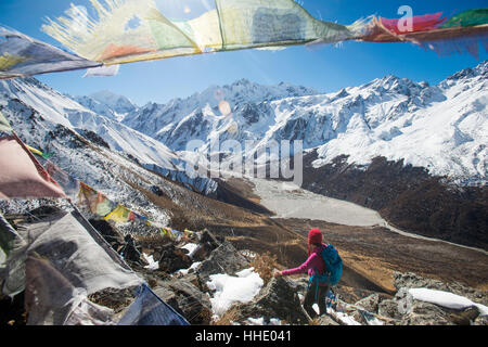A woman trekking in the Langtang valley in Nepal stands on the top of Kyanjin Ri, Langtang Region, Nepal Stock Photo