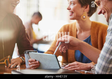 Smiling business people meeting using digital tablet in cafe Stock Photo