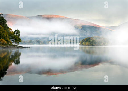 Mist over Derwent Water at dawn, from Brandlehow, Borrowdale, The Lake District National Park, Cumbria, UK Stock Photo