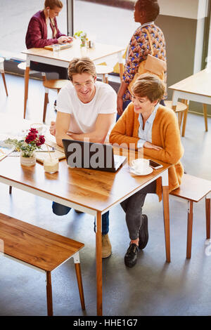 Business people drinking coffee working at laptop in cafe Stock Photo