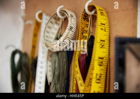 A row of hooks and tape measures on a tool board. Stock Photo