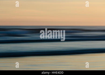 View from the beach over the ocean at sunset, long exposure Stock Photo