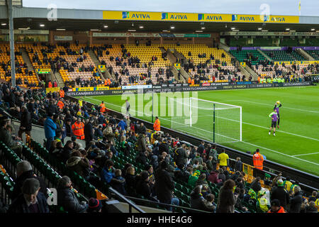 Norwich FC vs Brentford FC football match at Carrow Road Stadium. Fans arriving and watching the players warm up. Stock Photo