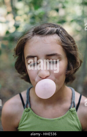 Eleven year old girl blowing bubble gum bubble Stock Photo