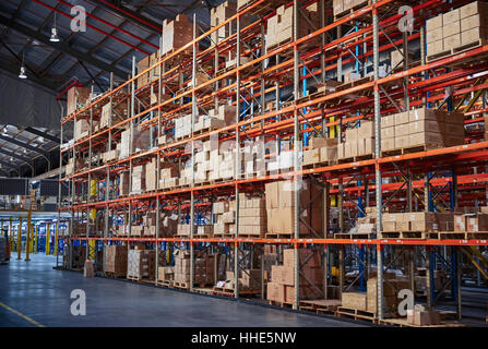 Cardboard boxes stacked on shelves in distribution warehouse Stock Photo