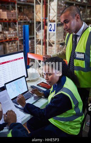 Managers meeting at laptop and computer in distribution warehouse Stock Photo