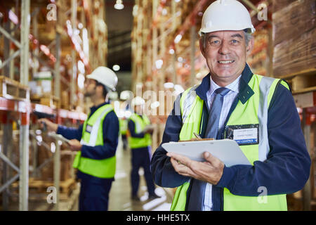 Portrait confident manager with clipboard in distribution warehouse Stock Photo