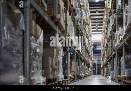 Merchandise cardboard boxes stacked on shelves in distribution warehouse Stock Photo
