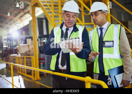 Managers with clipboard meeting talking in distribution warehouse Stock Photo