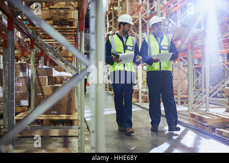 Workers walking with clipboards in distribution warehouse Stock Photo