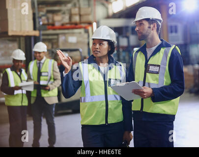 Workers with clipboard talking in distribution warehouse Stock Photo