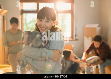 Portrait smiling young woman hugging stuffed elephant Stock Photo