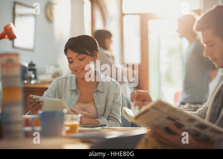 Young man and woman college students studying with book and digital tablet at table Stock Photo