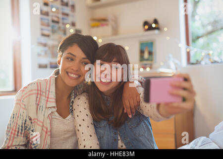 Enthusiastic young women friends taking selfie with camera phone Stock Photo