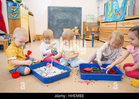 Children improving hands motor skills with rice and beans Stock Photo