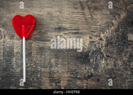 Red lollipops with heart shape on wooden background. Love concept. Valentine's Day. Stock Photo