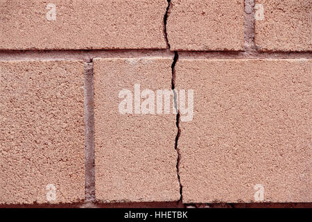 foreground of a vertical crack on a wall of bricks Stock Photo