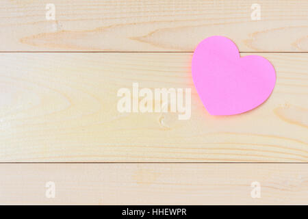 Pink sticky notes hearts shaped holes on wooden background with copy space Stock Photo