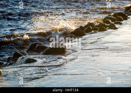 wavebreaker in the sea with waves crushing over in sunset Stock Photo ...