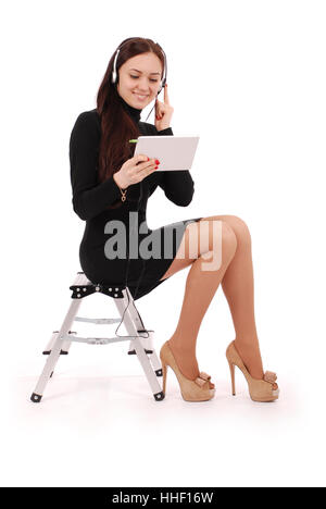 Happy student teenage girl sitting on the ladder looking at tablet pc at headphones isolated on white Stock Photo