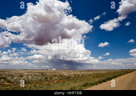 Blue sky with white cumulus clouds over and open farm field Stock Photo
