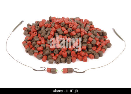 Fishing bait with hook and brown with red pre-drilled halibut pellets for carp fishing isolated on white background with soft sh Stock Photo