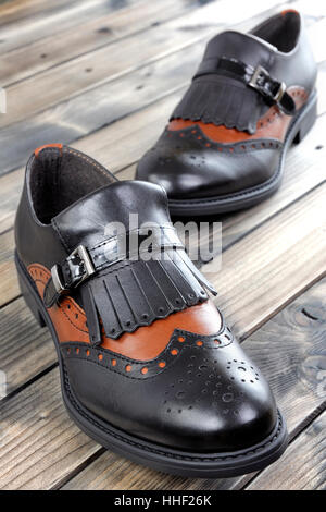 Women's shoes with low heels leather black and brown, photographed on an old wood table. Stock Photo
