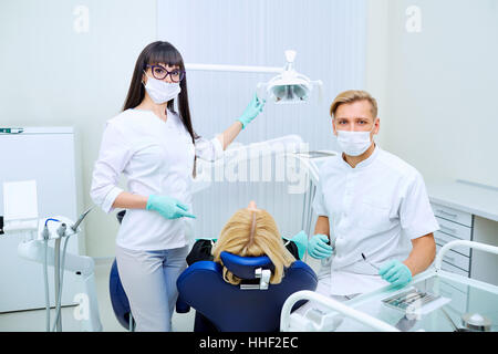 The patient, dentist and assistant in office of a dental clinic Stock Photo