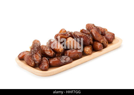 date palm dried fruit in wooden plate isolated on white background with clipping path Stock Photo