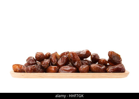 date palm dried fruit in wooden plate isolated on white background with clipping path Stock Photo