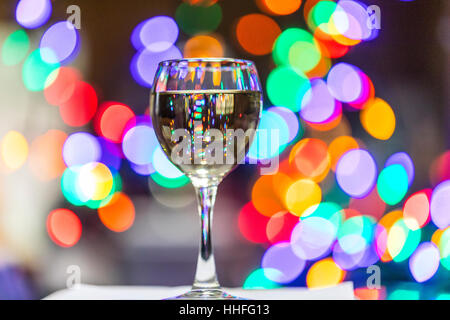 A glass of Pinot Grigio white wine with sparkling lights in the background Stock Photo