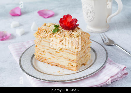 Napoleon cake, layered cake with pastry cream, custard decorated with strawberry rose and mint. Close up view. Piece of homemade Stock Photo
