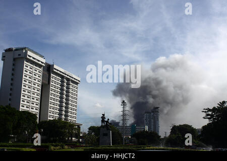 Jakarta, Indonesia. 19th January 2016. Dark smoke soared in the sky as seen from Tugu Tani (Farmer Monument) area, about 800 meters from the burning Pasar Senen shopping center building, Jakarta. The fire was reported at 4:45 am, and has been no report on the causes and casualties in the incident. Senen Market is one of the largest economic center in Jakarta, which was built in the Dutch colonial period in 1735. The name was taken because the first Senen market trading activity is only done on Monday, but over time the activity was happening every day. Credit: PACIFIC PRESS/Alamy Live News Stock Photo